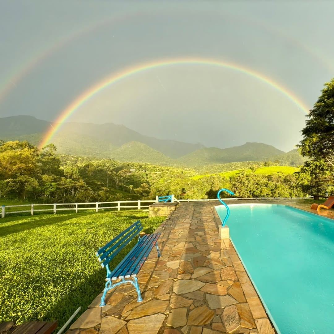 Piscina com arco-íris e vista para as montanhas